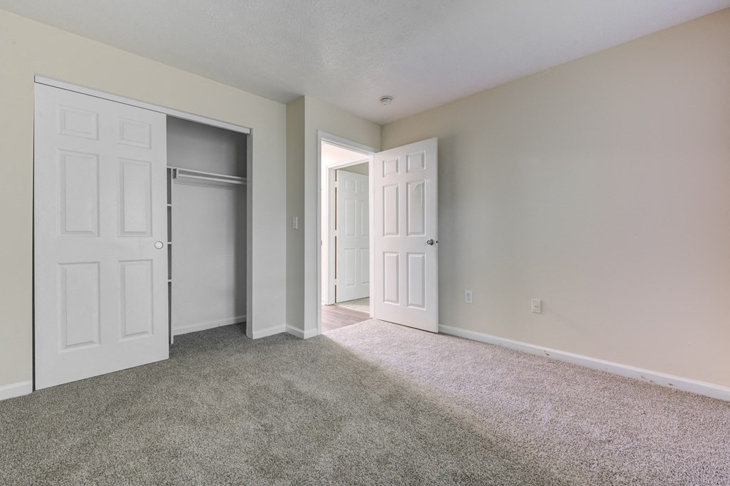 Bedroom with a closet, white doors and a carpeted floor at Brownsburg Pointe.