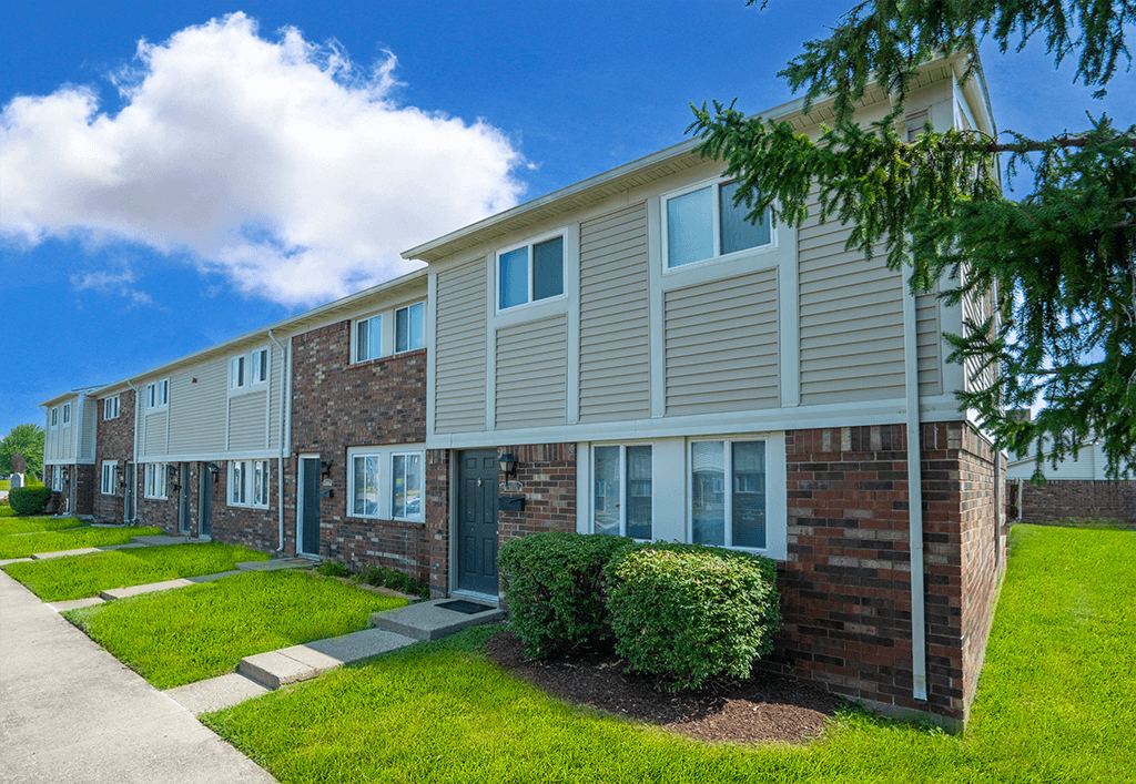 Exterior view of a building at Colonial Village Apartments, showcasing well-maintained landscaping and a classic design.