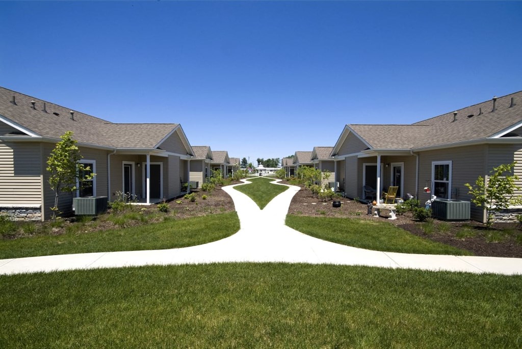 Wide view of Meredith Meadows Apartments exterior with landscaped lawn and trees.