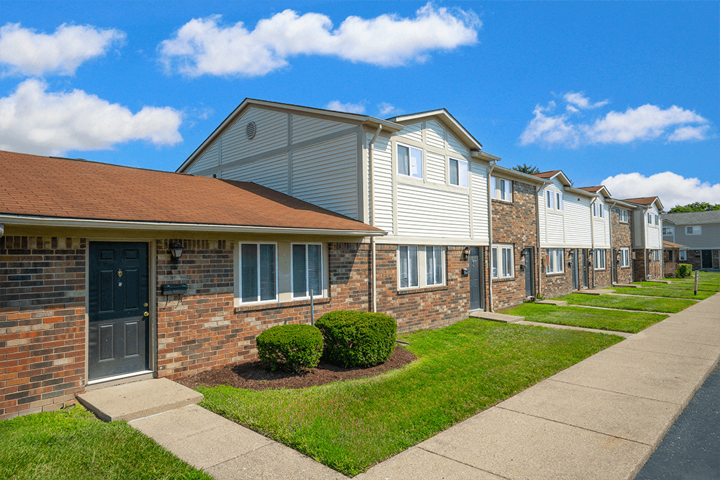 Exterior view of a building at Colonial Village Apartments, showcasing well-maintained landscaping and a classic design.