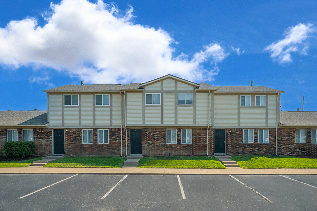 Building exterior with adjacent parking at Colonial Village Apartments.
