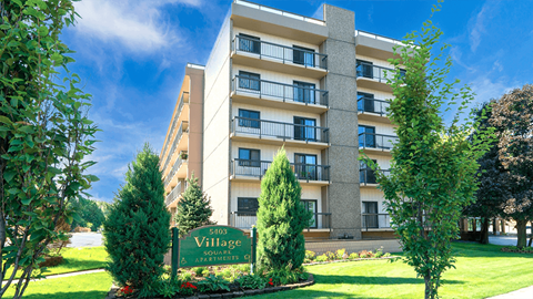 Exterior view of Village Square Apartments showcasing the building's design and landscape.