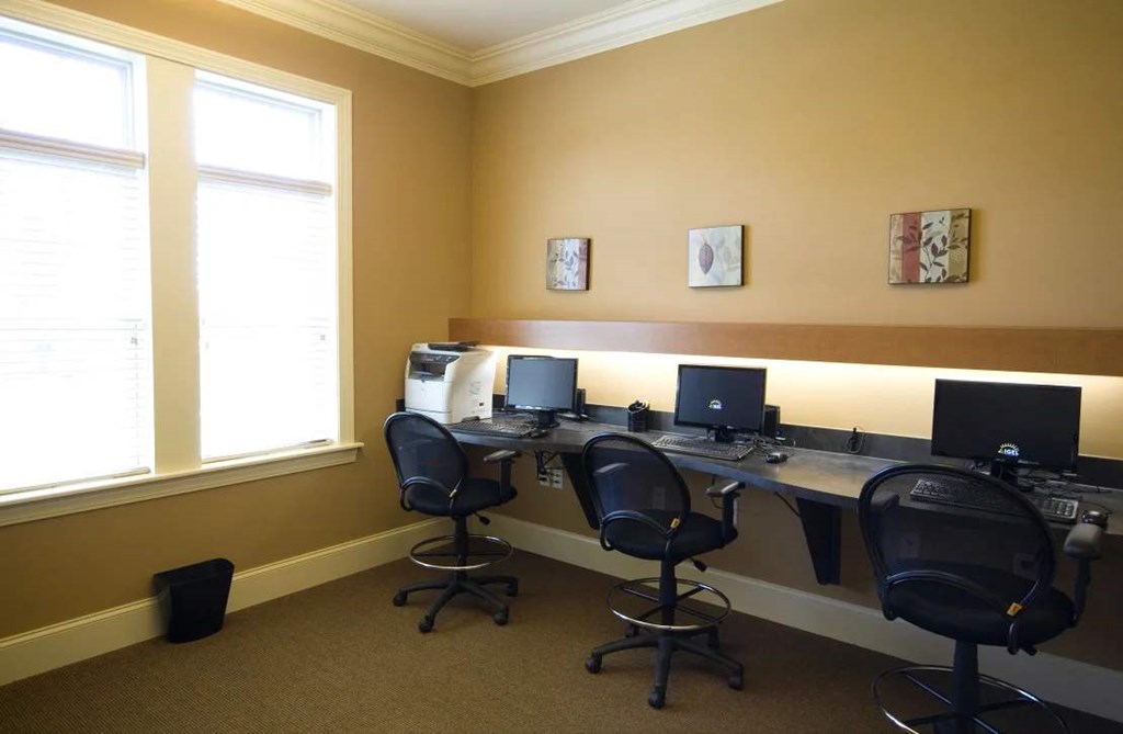 Business center at Meredith Meadows Apartments with desks, computers, and seating.