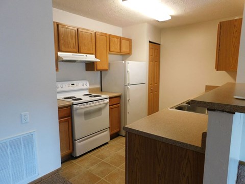 a kitchen with white appliances and wooden cabinets
