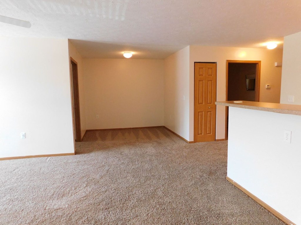 Unfurnished living room with an open kitchen in the background at Chapelgate Park Apartments