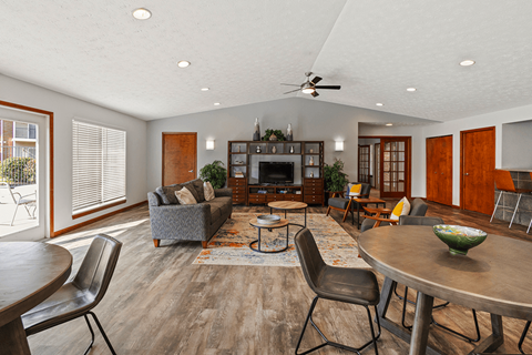 A modern living room with a grey couch, a wooden coffee table, and a television.