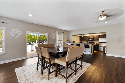 A dining room with a table and chairs.