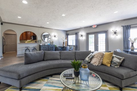 a living room with a gray couch and a glass coffee table