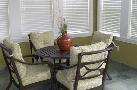 Clubhouse interior at Four Seasons at Hawthorne Apartments, featuring seating area.