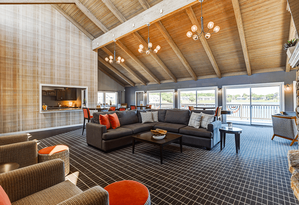 Clubhouse at Somerset Lakes Apartments, featuring a large open living room with a fireplace and a balcony for relaxation.