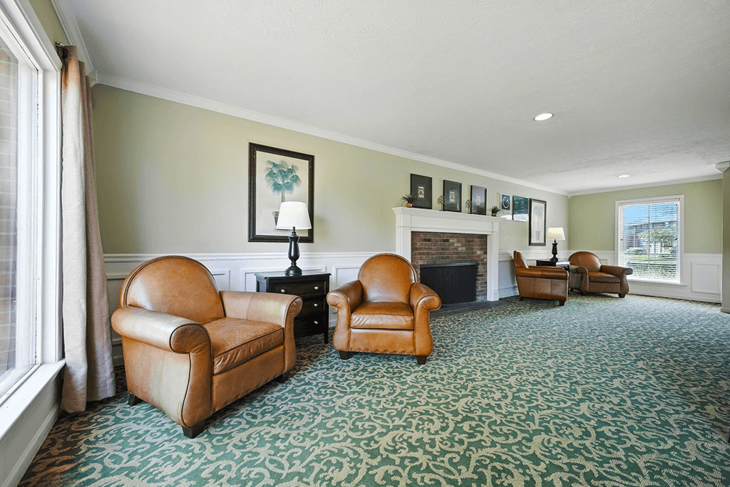 Community room with a fireplace and seating  at Ashton Pointe Apartments.