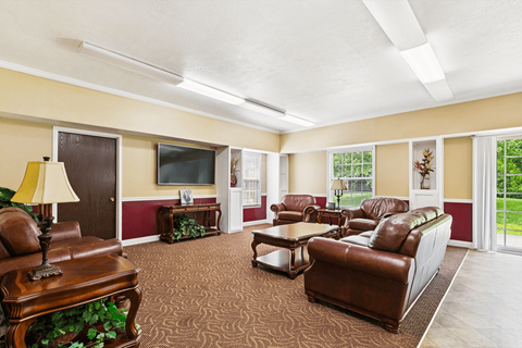 A living room with brown leather furniture and a flat screen TV.