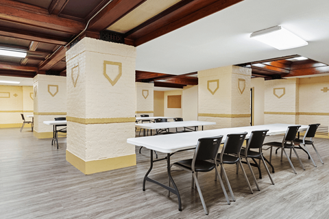A conference room with tables and chairs and a white table with black chairs.