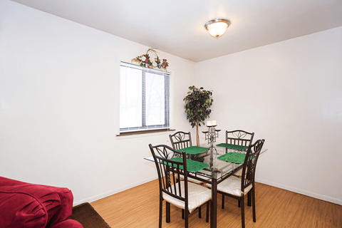 A dining room with a table set for four.