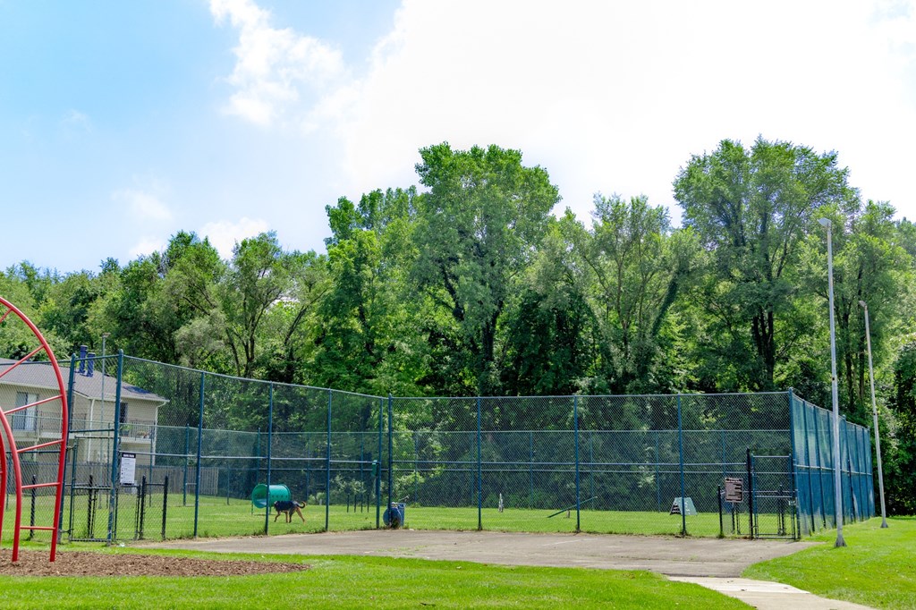 a park with a playground and a chain link fence