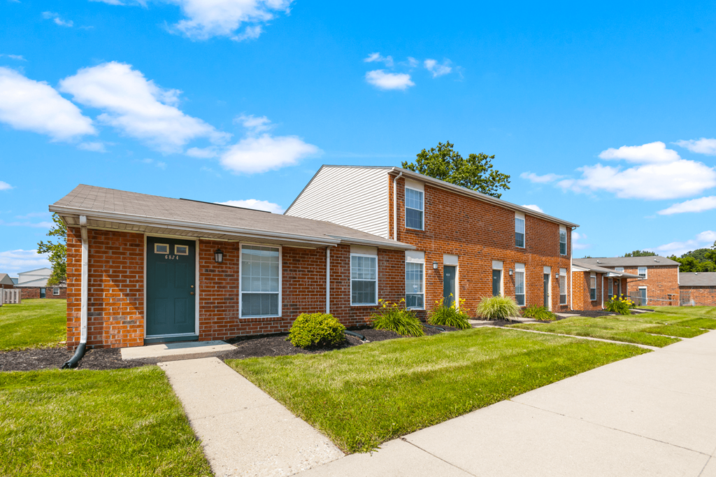 Exterior view of Windsor Park Apartments, with well-maintained landscaping, and inviting entryways.