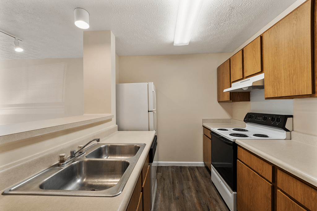 Kitchen in a 1-bed, 1-bath apartment at Brownsburg Pointe, featuring a stove, sink, and cabinets.