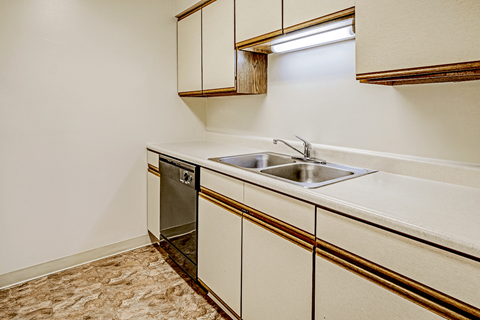 kitchen in a 1-bed, 1-bath apartment at Thompson Village, featuring countertops, cabinets and a dishwasher..
