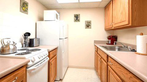 A kitchen with a white stove and white refrigerator.