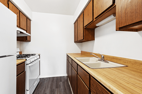 A kitchen with wooden cabinets and a white stove.