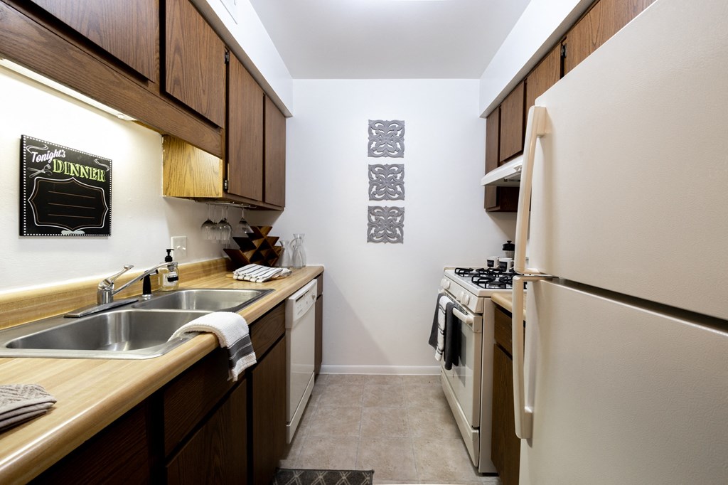 2 bedroom Kitchen at University Park Apartments a kitchen with a sink and refrigerator and a stove