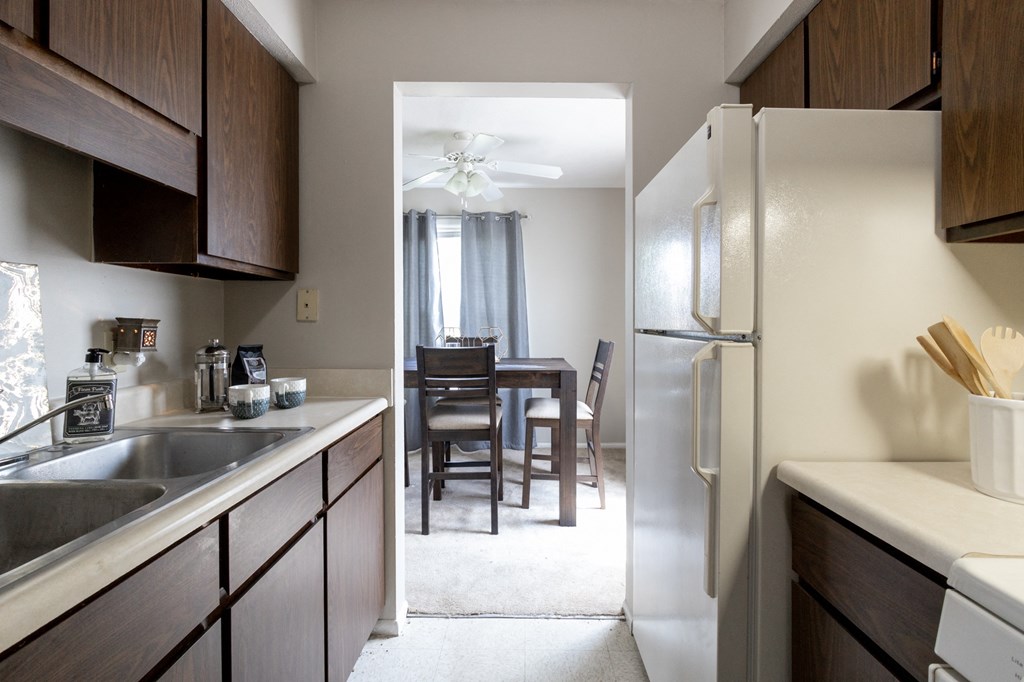 an open kitchen and dining room with a table and a refrigerator