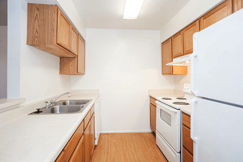 A kitchen with wooden cabinets and white appliances.