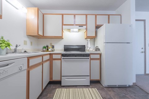 a kitchen with white appliances and wooden cabinets