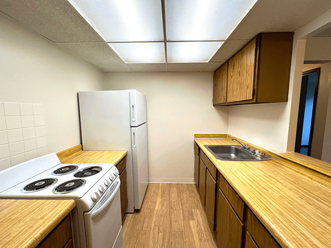 A kitchen with a white stove and a white refrigerator.