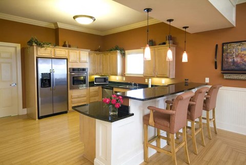 A kitchen with a bar area and chairs.