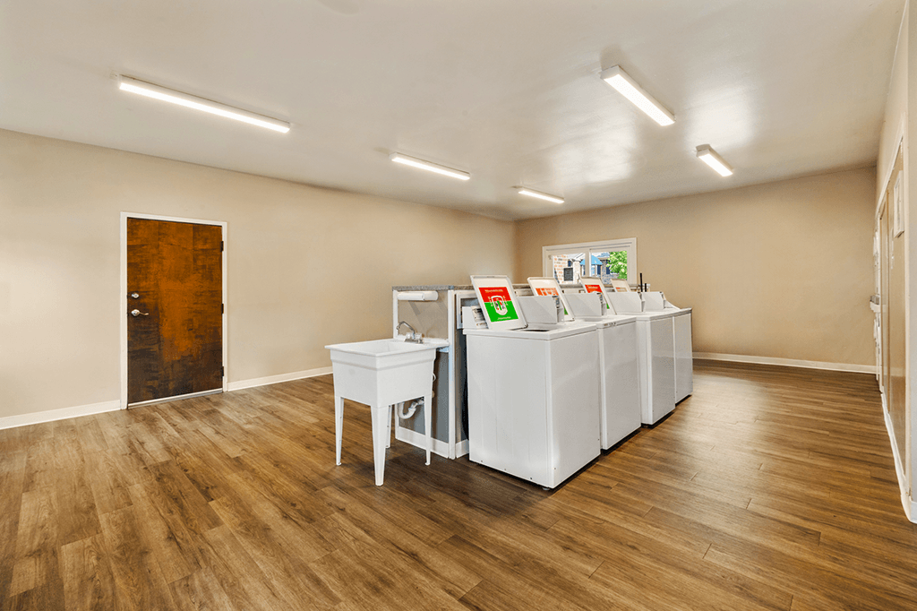 Laundry facility at Carriage House Apartments in Kendallville, featuring multiple washers and dryers.