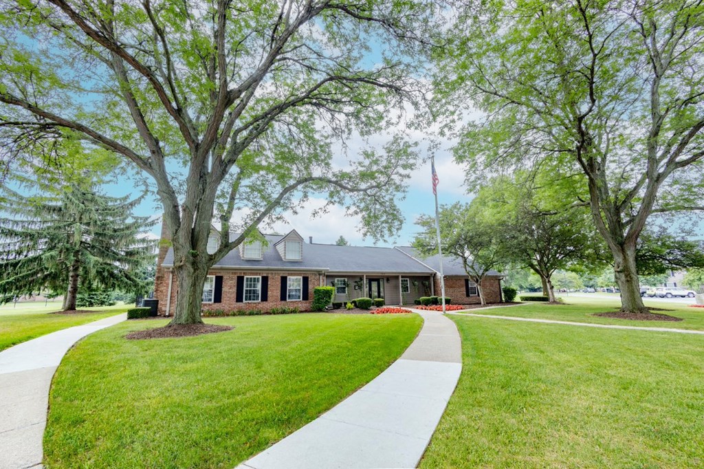 the front of a house with trees and a sidewalk