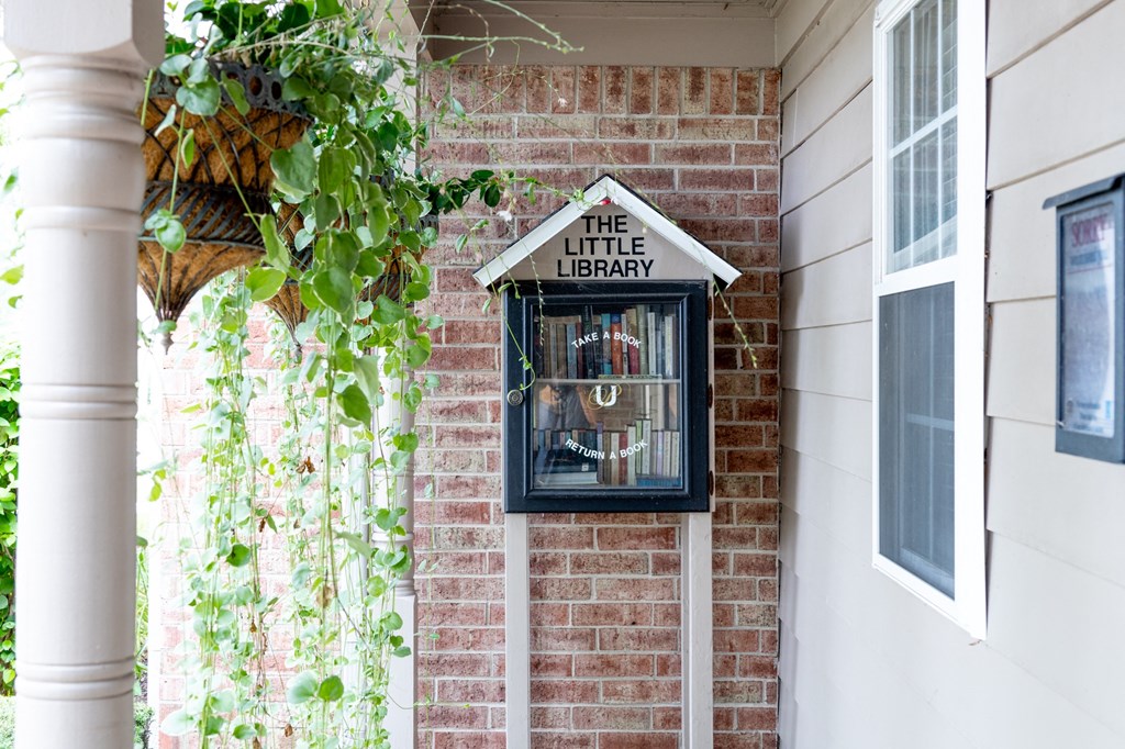 a little library sign on the side of a brick building