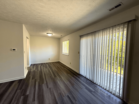 A room with a window covered by white blinds.