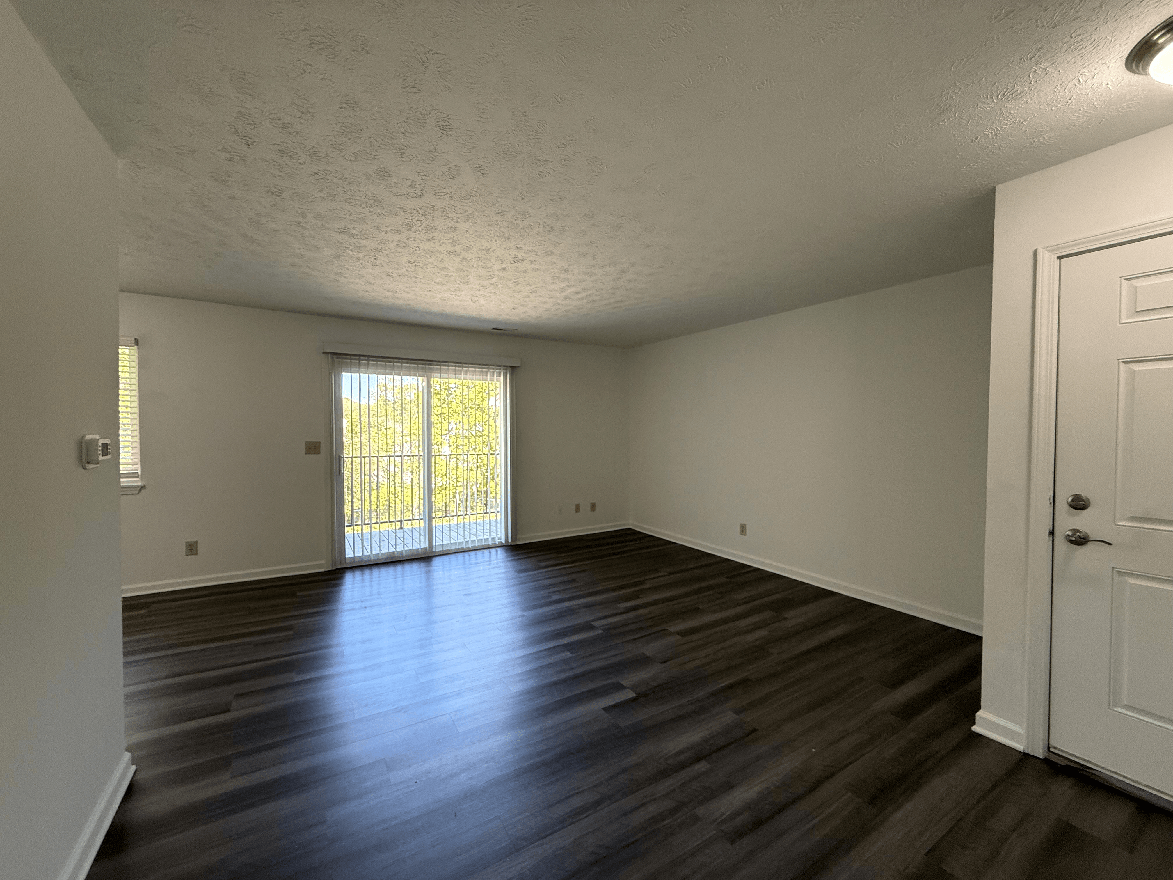 A room with wooden floors and a sliding glass door.