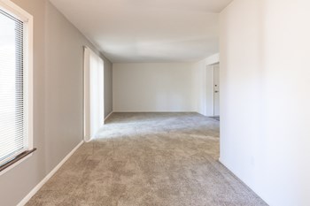 Open living and dining space with patio access in a 2 Bedroom Apartment  at Woodlake Apartments - Photo Gallery 12