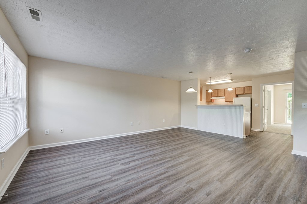 Living room and kitchen with wood flooring at Brownsburg Pointe.