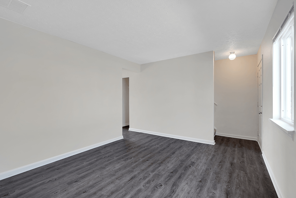 Living room in a 2-bed, 1-and-a-half-bath townhome at Colonial Village Apartments, featuring a spacious layout and natural lighting.