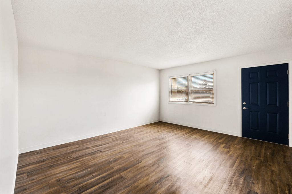 Living room in a 2-bedroom, 1-bathroom townhome at Country View Apartments, featuring hardwood floors, and windows.
