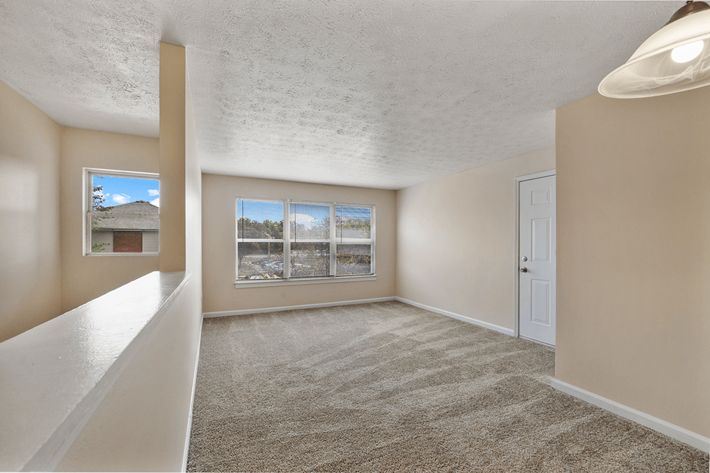 Living room in a 3-bed, 2-bath apartment at Brownsburg Pointe with carpeted floors.