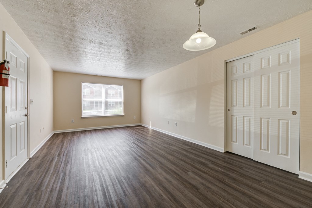 Living room with a window,  wood flooring and white doors at Brownsburg Pointe.