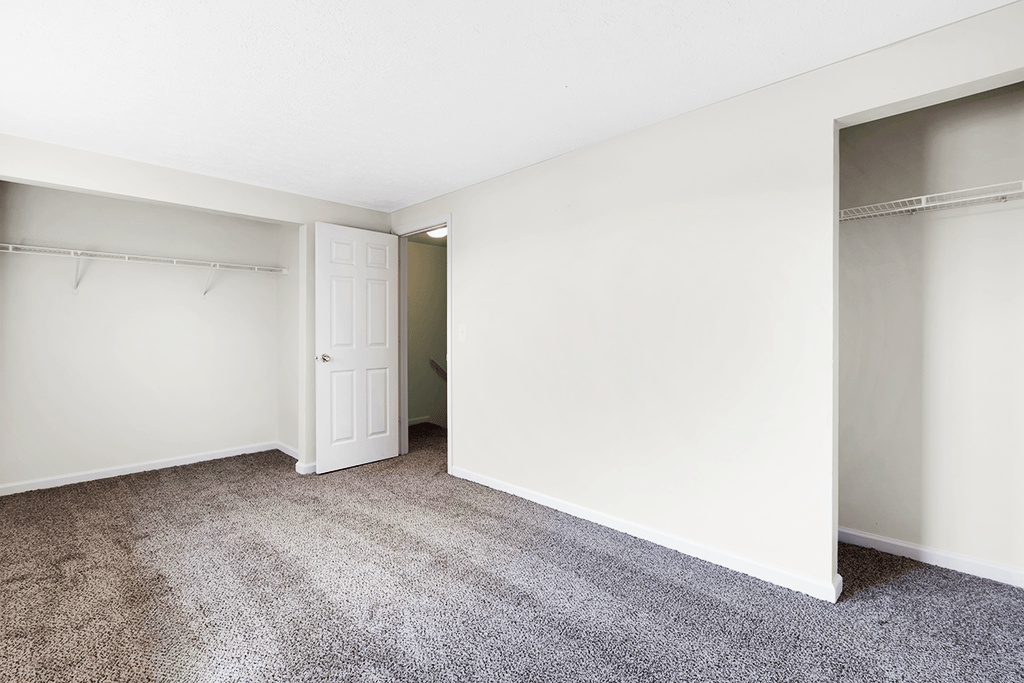 Master bedroom in a 2-bed, 1-and-a-half-bath townhome at Colonial Village Apartments, featuring a spacious layout and closets.