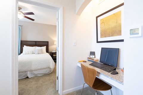 A bedroom with a bed, desk, and chair.