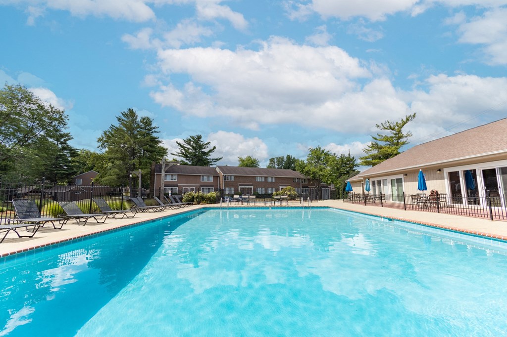 Outdoor swimming pool with seating at Woodbridge Apartments