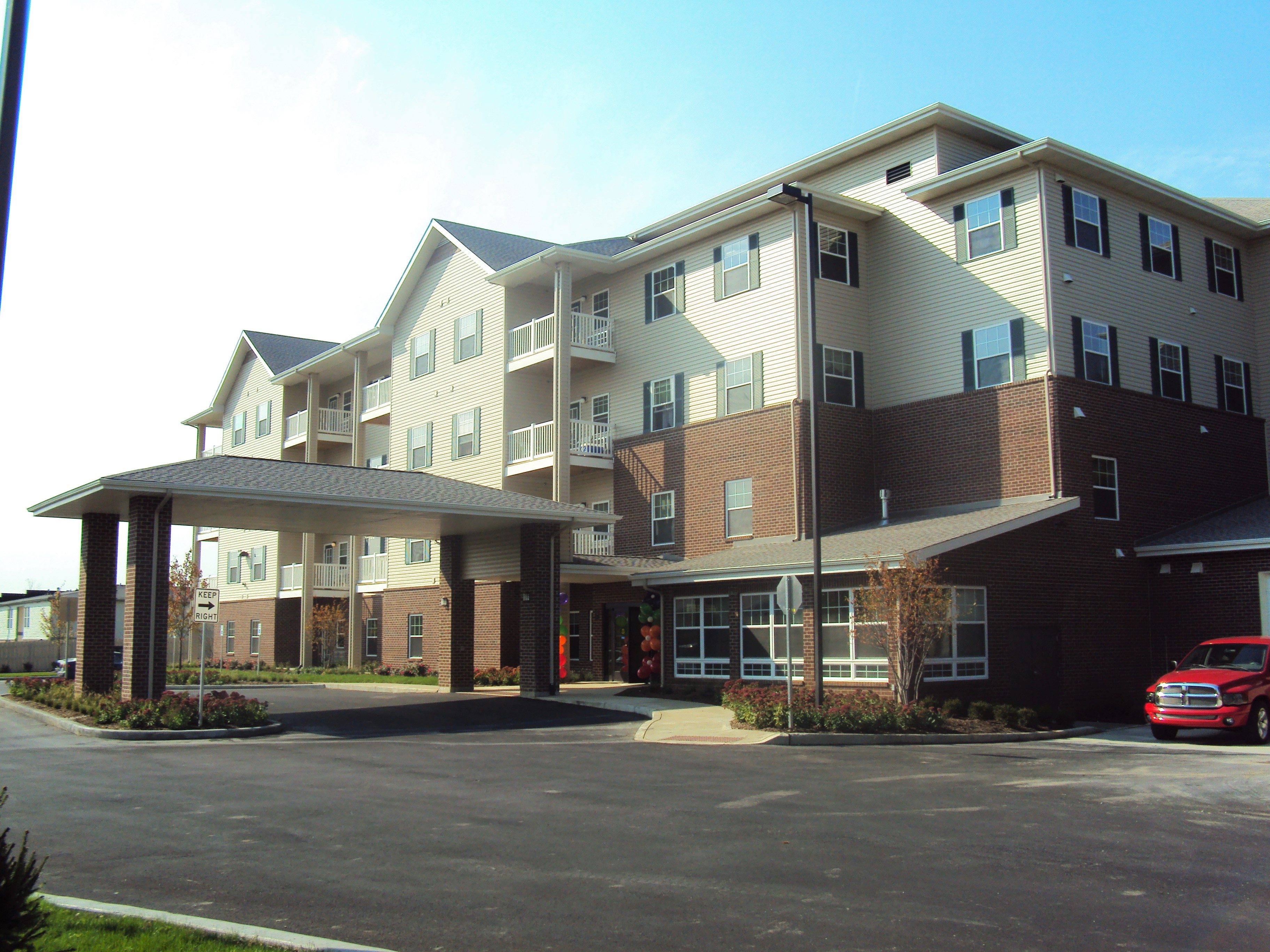 A large apartment building with a parking lot in front.