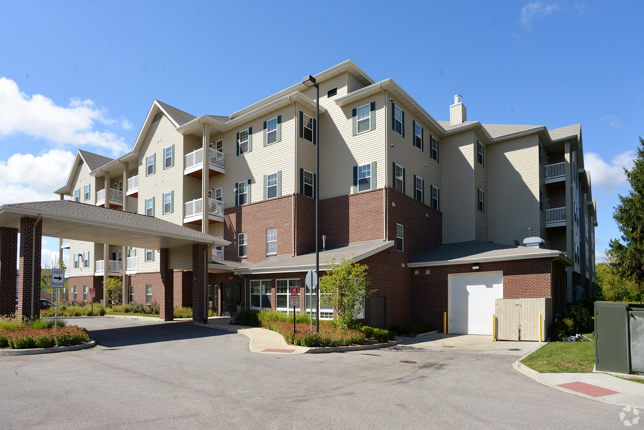A large apartment complex with a parking lot in front.
