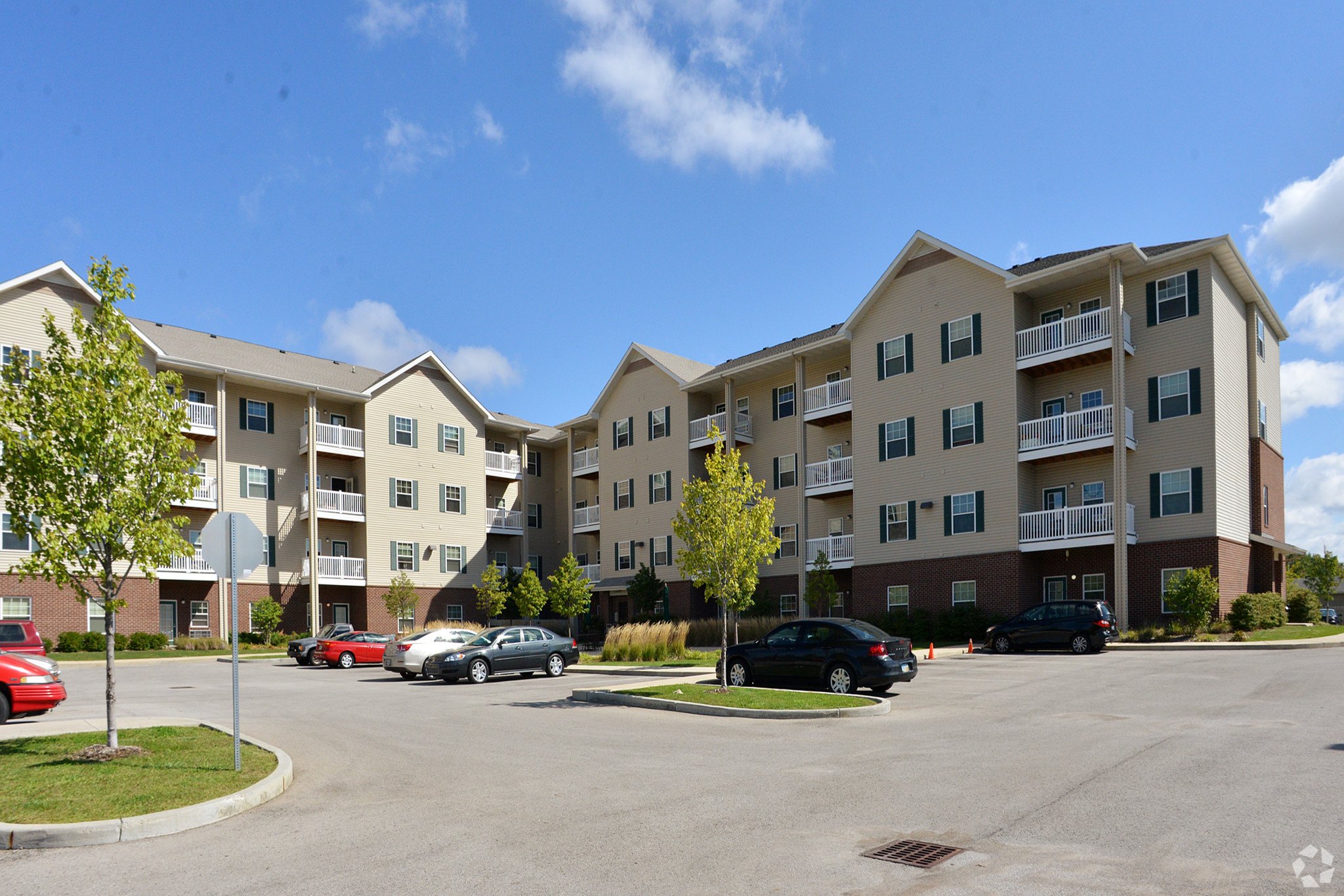 Apartment complex with cars parked in front.