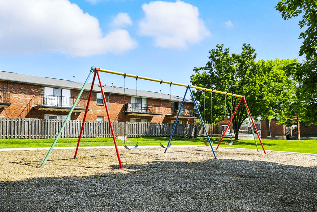 Playground with a swing set  at Ashton Pointe Apartments.