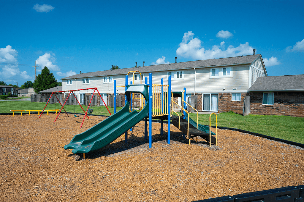 Playground at Colonial Village Apartments, featuring slides and swings.