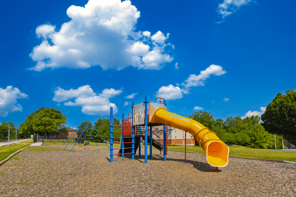 Colorful playground at Country View Apartments, featuring swings, slides, and play structures.